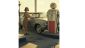 Vintage 1960s scene of classic car at gas station with retro fuel pump and stylish driver